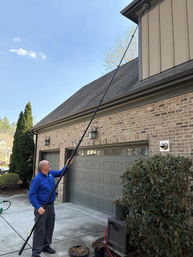 Ready Pest Solutions technician treating the exterior of a home