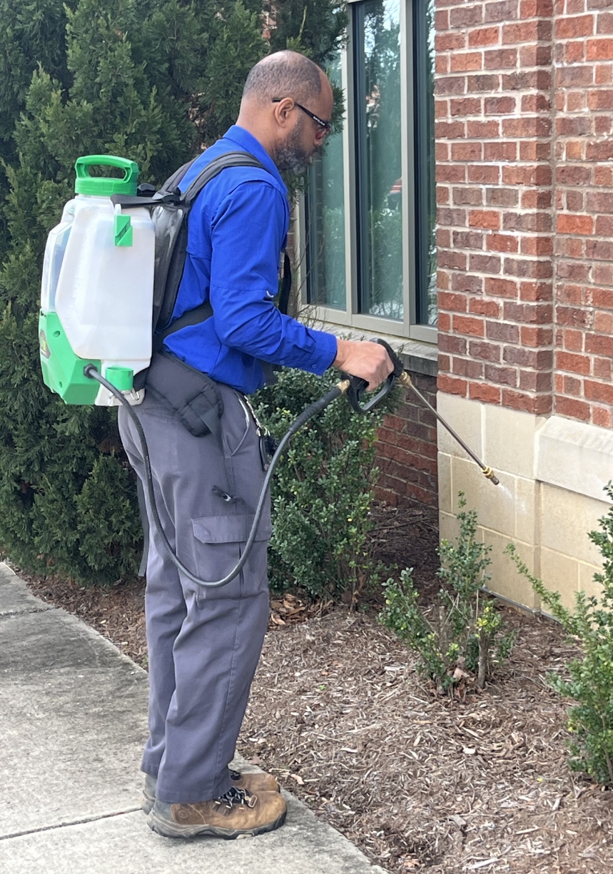 solutions image Ready Pest Solutions technician treating a commercial building exterior